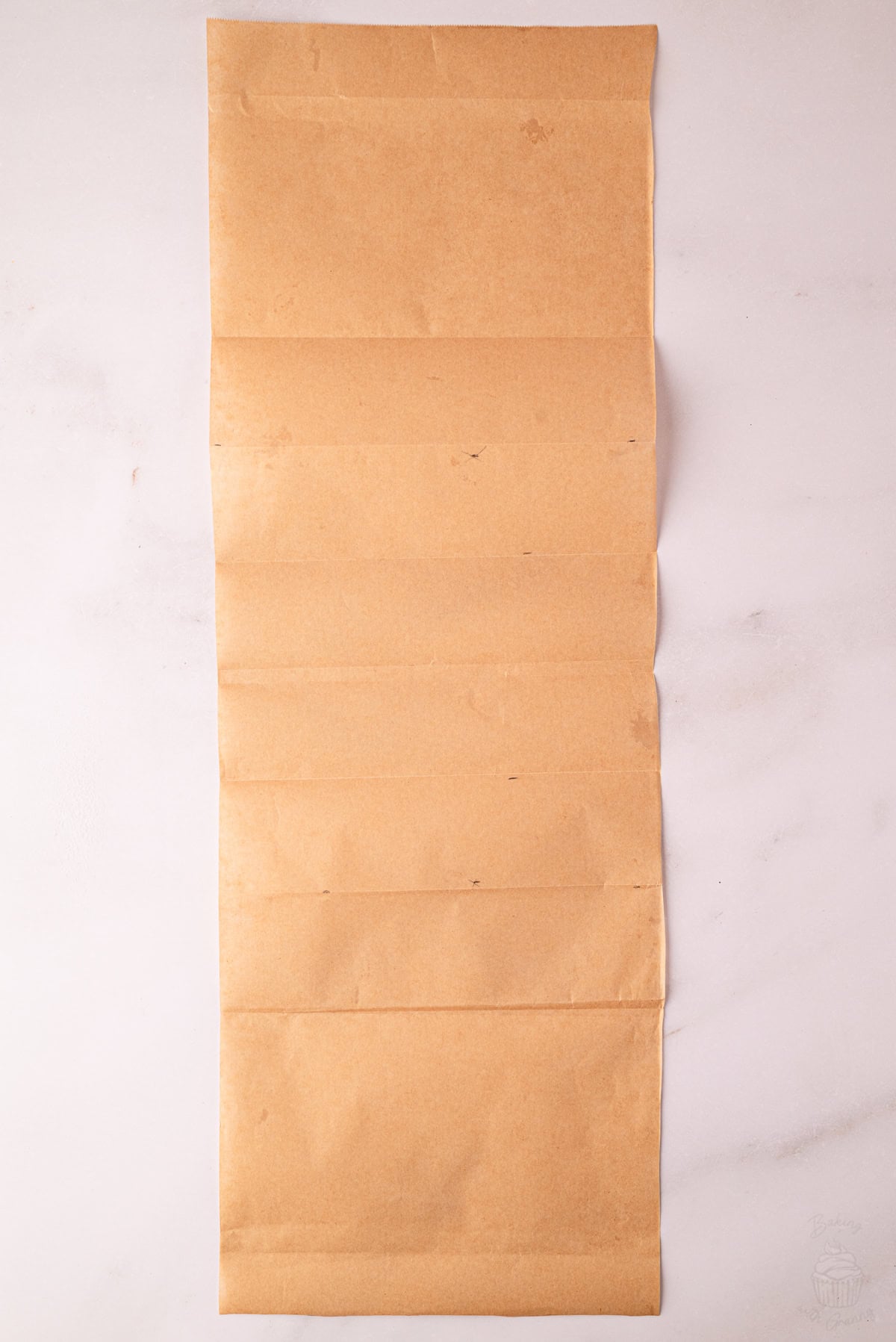 Large sheet of greaseproof paper folded for dividing an Angel Cake baking tin.