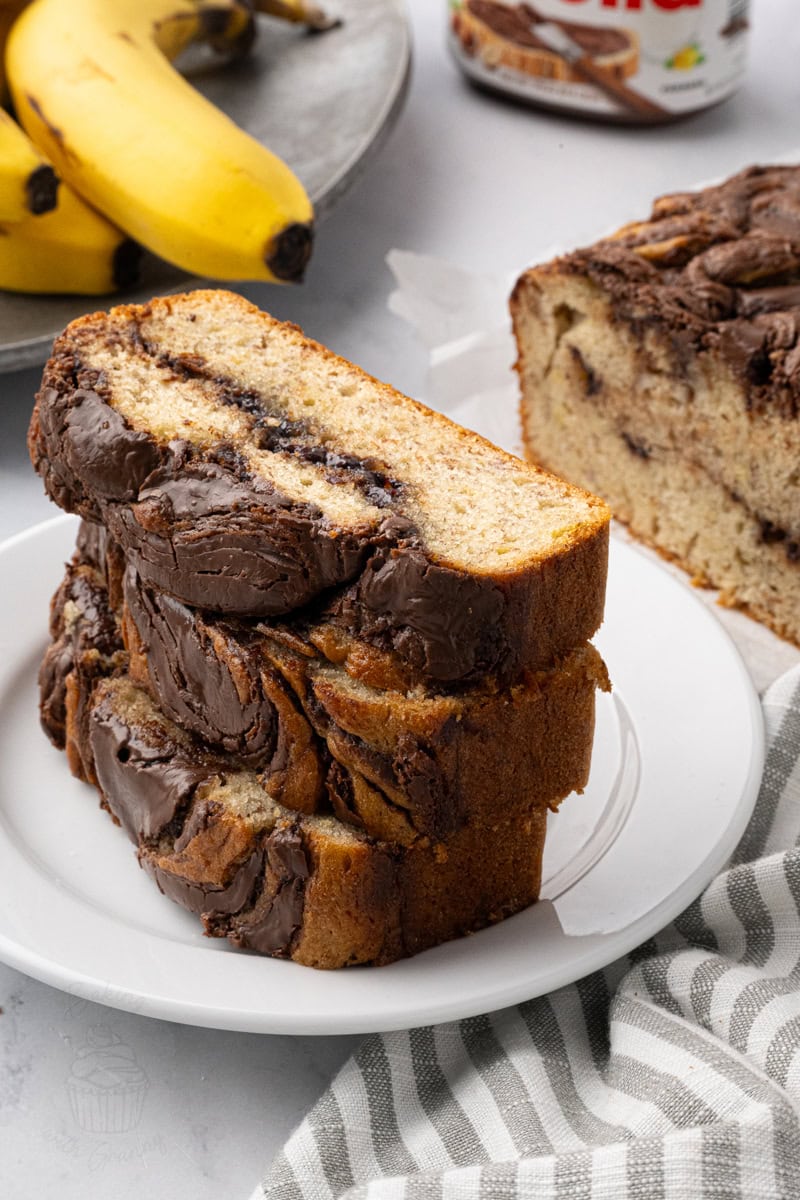 Stacked slices of banana Nutella loaf cake with thick Nutella swirls