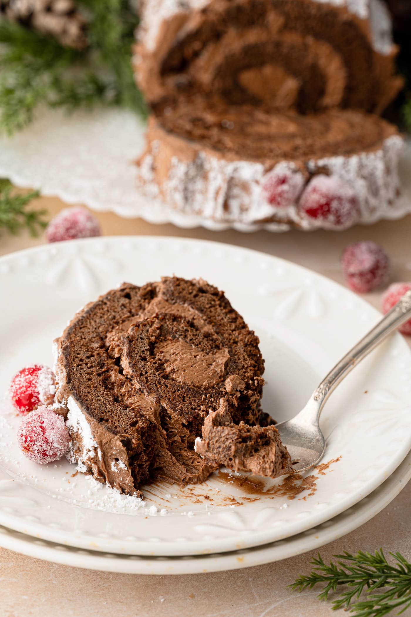 Slice of chocolate Yule Log showing the cocoa sponge and chocolate buttercream filling.