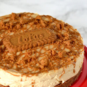 Close-up of creamy Biscoff cheesecake with biscuit base, Lotus biscuit on top, and caramelised biscuit crumb decoration.