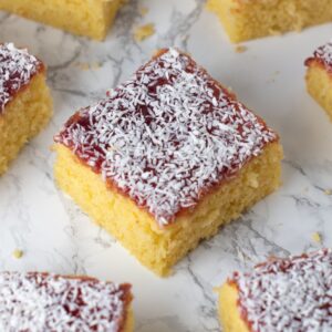 Jam and coconut school cake topped with raspberry jam and desiccated coconut.