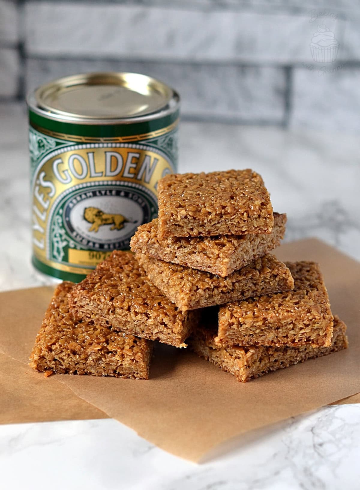 Flapjack squares beside a tin of Lyle’s Golden Syrup.