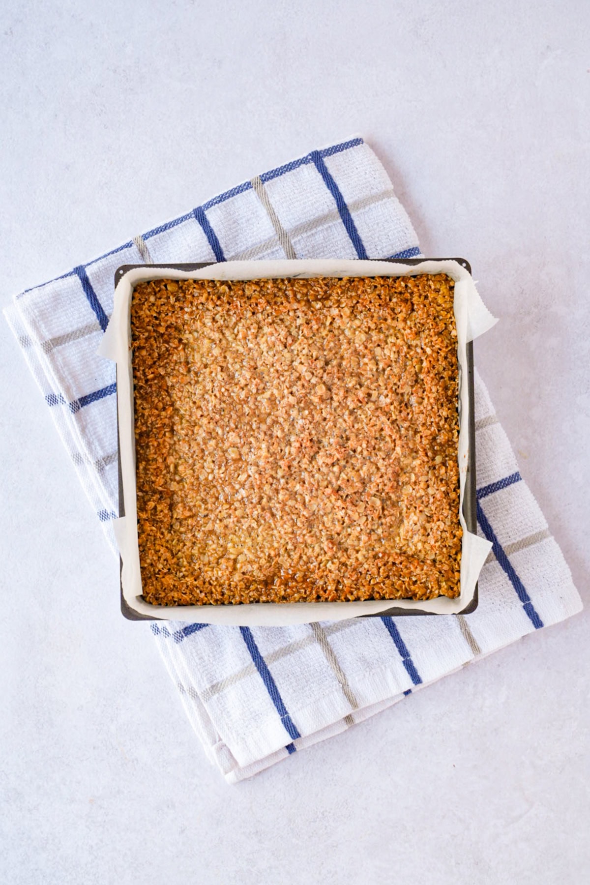 Freshly baked flapjack in the tin with lightly golden edges and a softer centre.