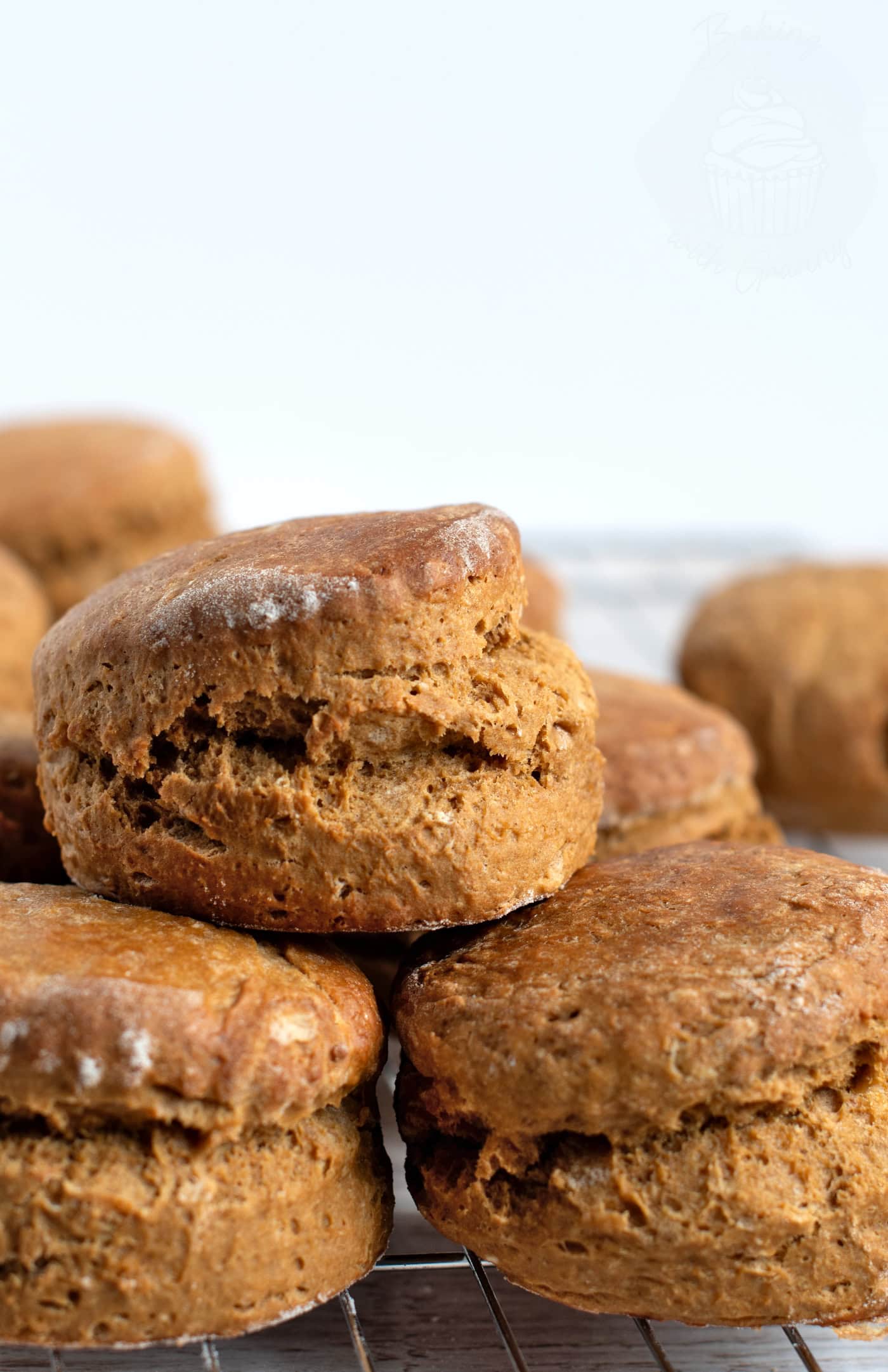 Show thumbnail preview Close-up of several freshly baked, golden brown old-fashioned treacle scones stacked on a cooling rack. The scones have a slightly rustic appearance.