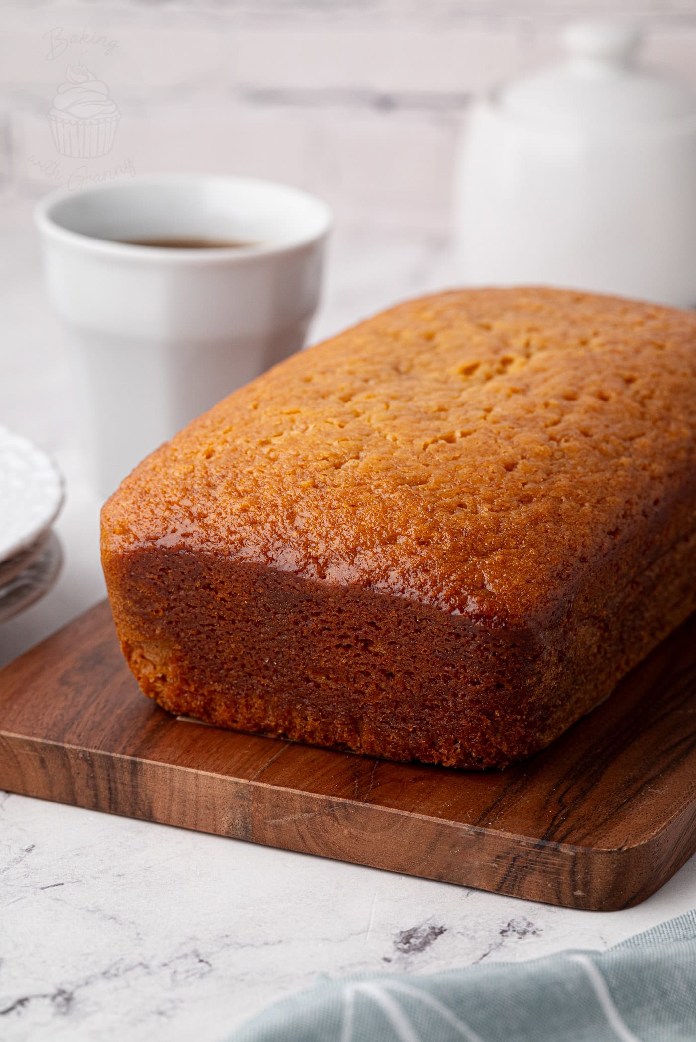 Whole golden syrup loaf cake from the back, showing its golden crust.