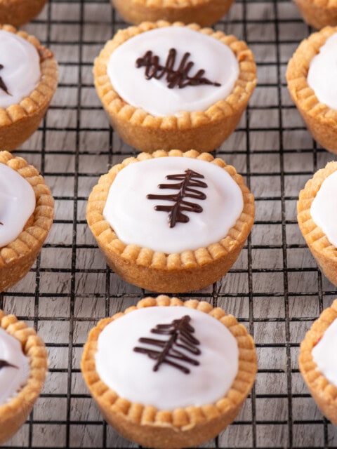 Overhead view of iced Fern Cakes with piped chocolate decorations, arranged neatly on a wire cooling rack.