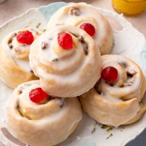 Belgian Buns topped with white icing and red glacé cherries.