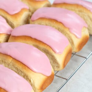 Soft iced finger buns topped with sweet pink icing.