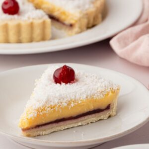 Manchester Tart with custard, coconut and glacé cherries in a pastry case.