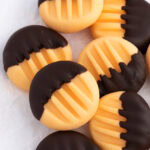 Homemade orange creams half-dipped in dark chocolate, arranged on baking paper - easy Christmas gift idea.