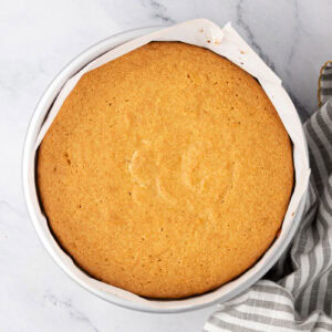 Overhead view of a homemade Madeira cake cooling in a parchment-lined tin.