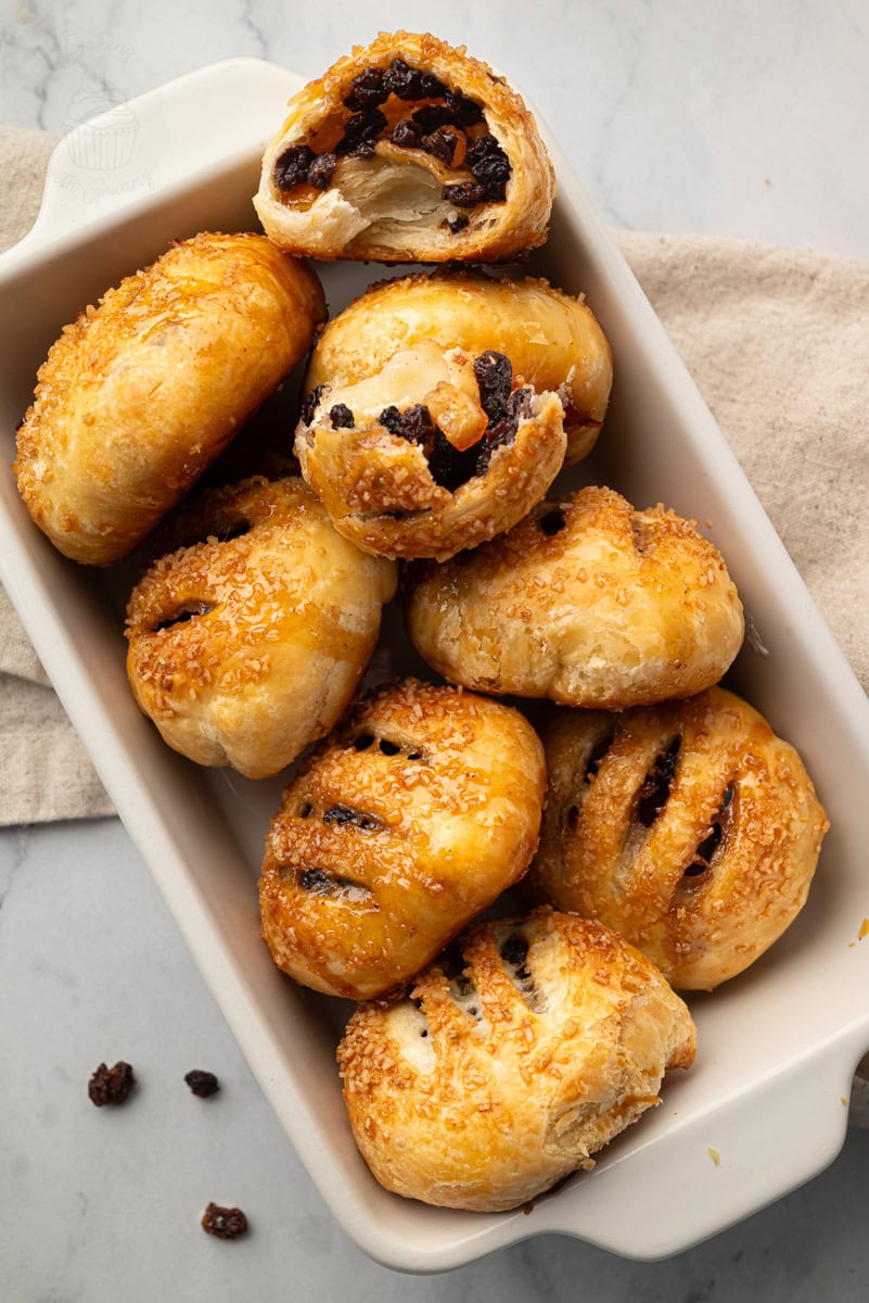 Eccles cakes served on a plate with one opened to show the fruit filling.