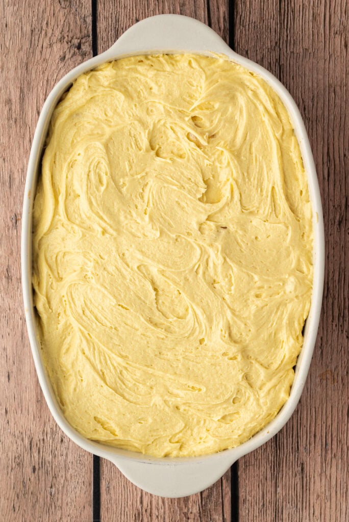 Sponge mixture spread evenly over the apples before baking.