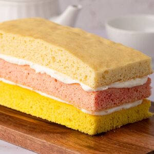Slices of pink, yellow and plain Angel Cake layered with buttercream.
