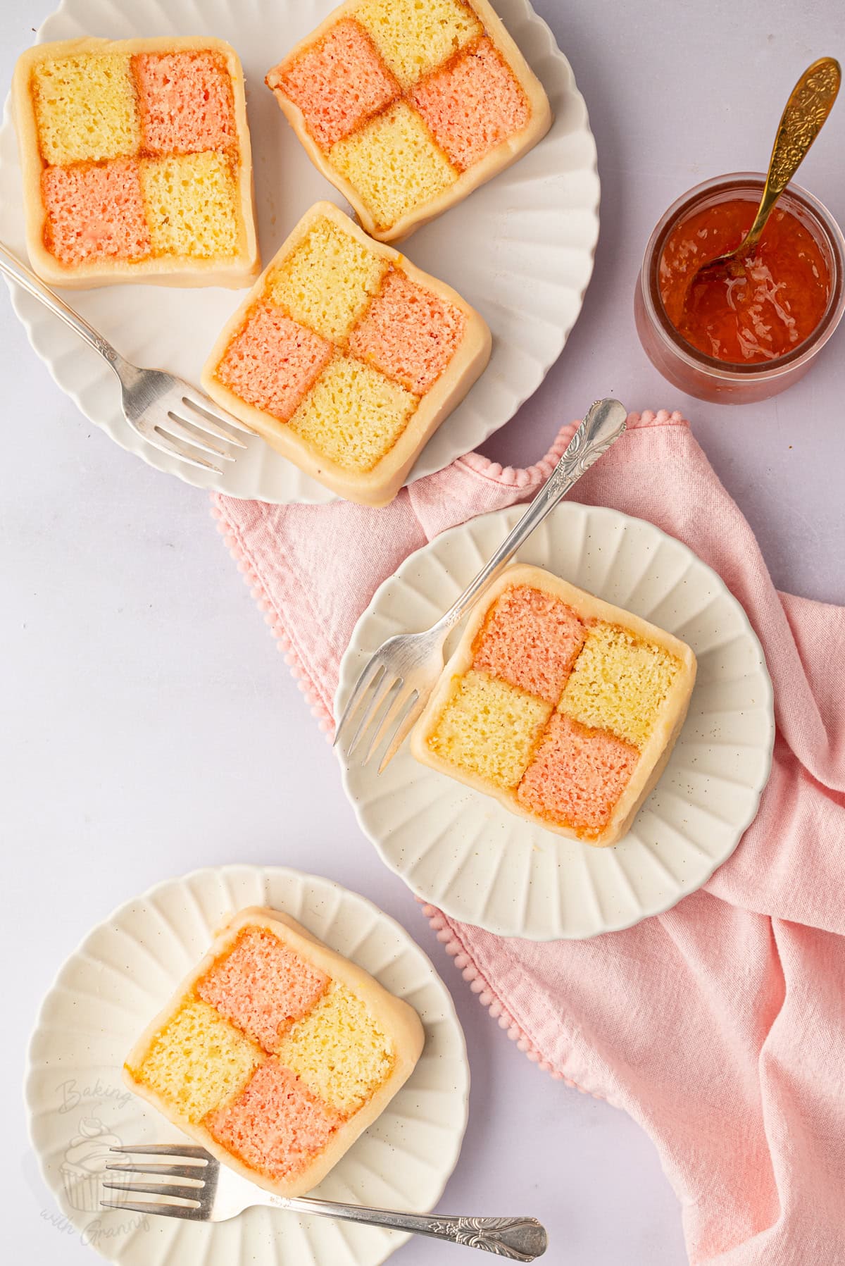Slices of Battenberg cake showing the pink and plain checkerboard sponge.