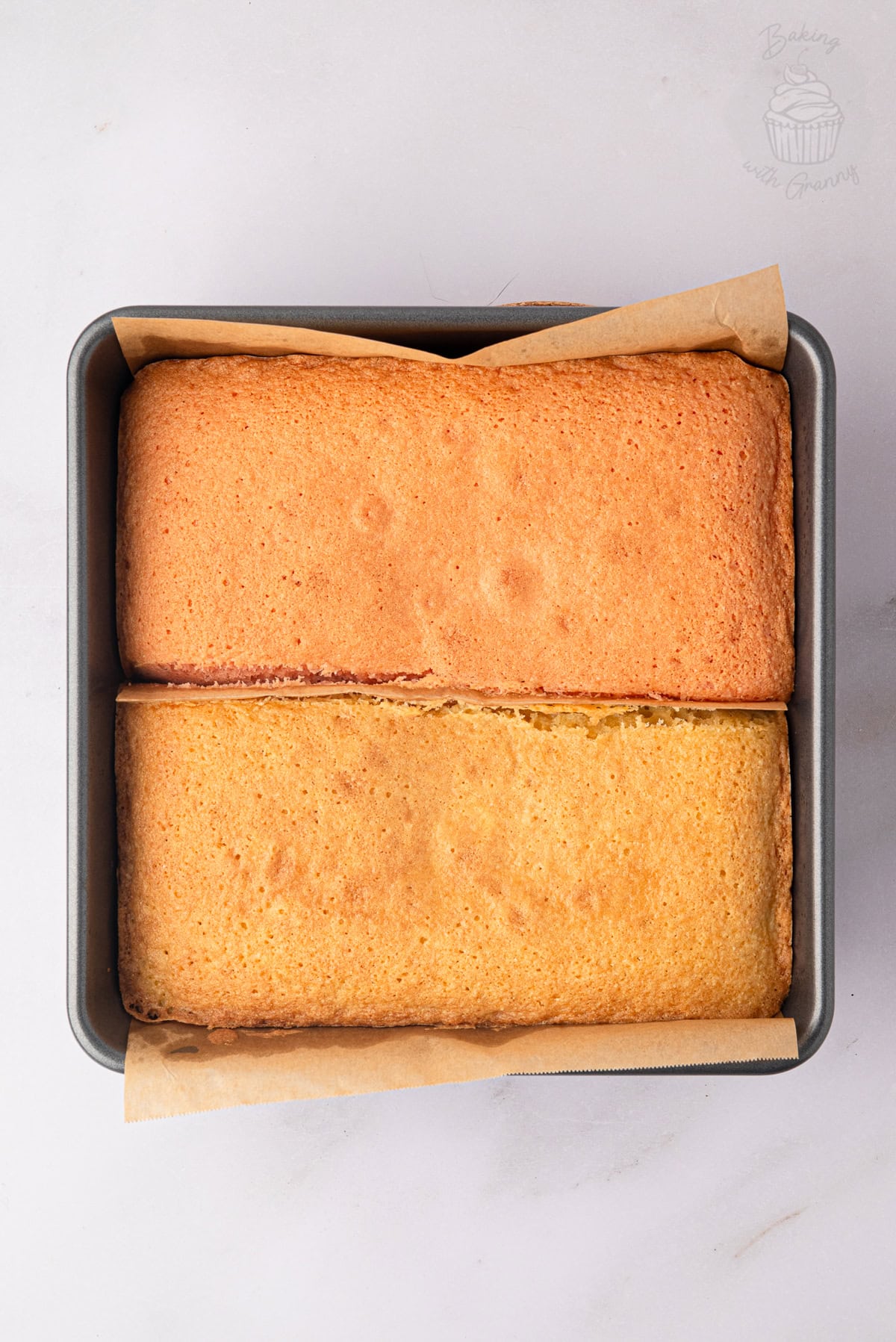 Baked pink and plain Battenberg sponges in a square cake tin.