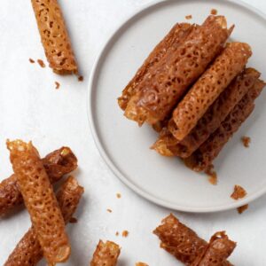 Golden rolled Brandy Snaps showing their crisp, delicate lacy texture.