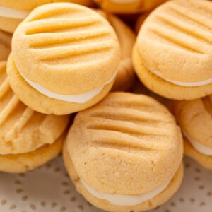 Stacked homemade Custard Creams showing ridged biscuits and creamy buttercream filling.