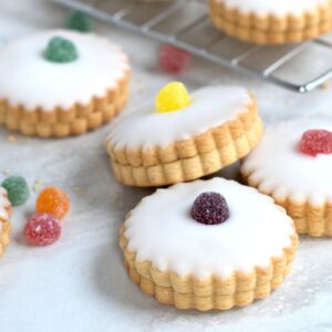 Empire Biscuits filled with jam and topped with icing and colourful sweets.