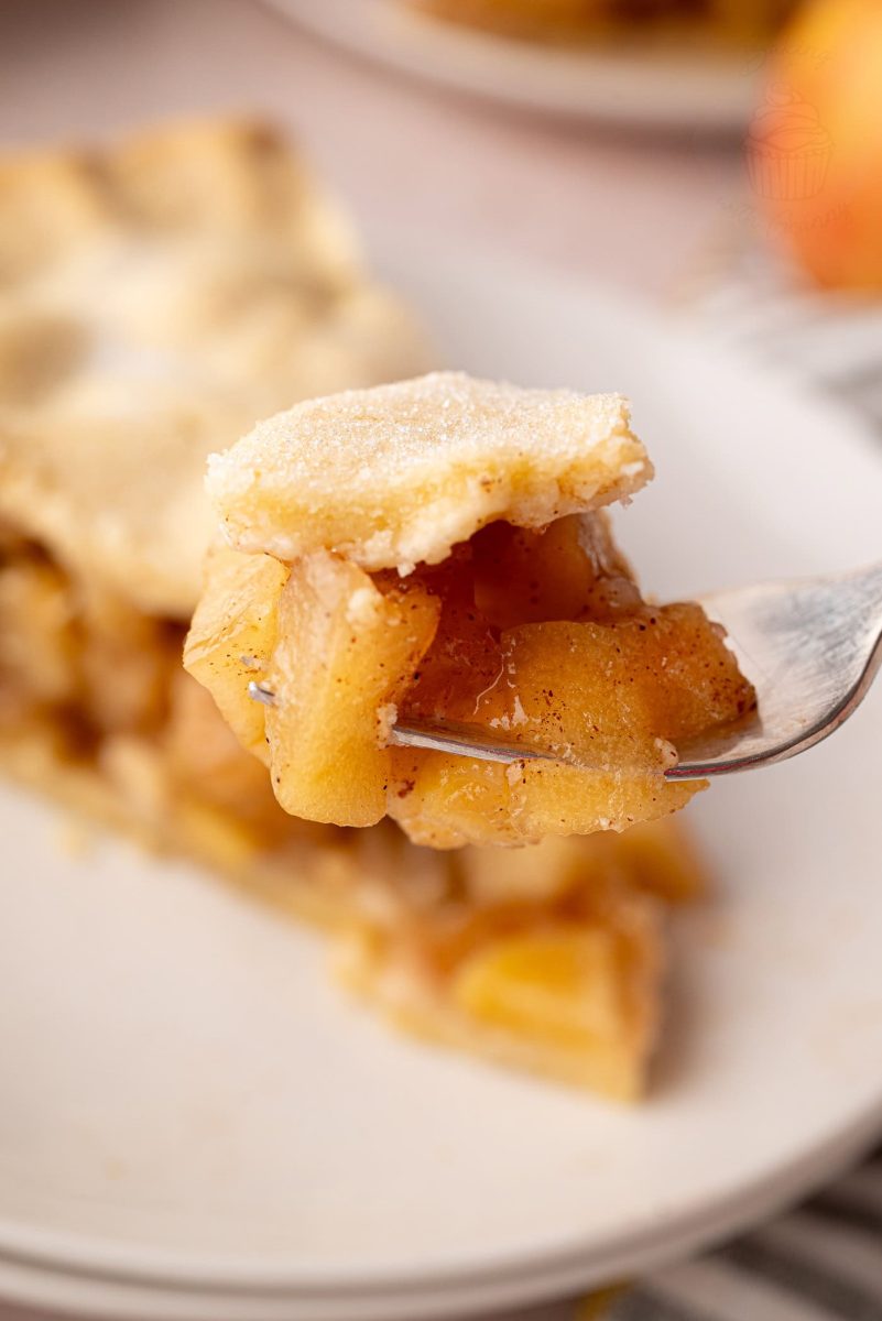 Apple Pie Close-up of a forkful of apple pie, showing tender spiced apple slices and buttery pastry - part of an apple pie UK recipe.