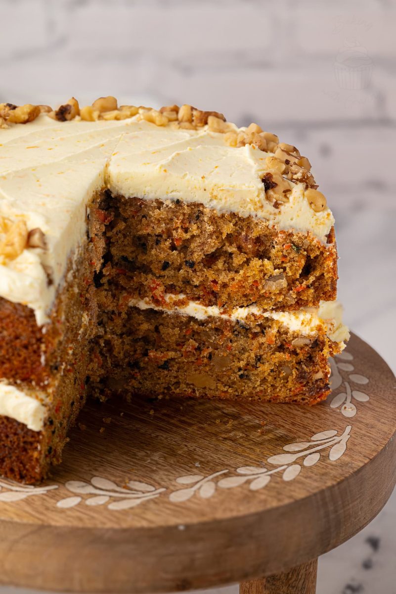 Carrot Cake Close-up of the inside of a carrot cake, showing its soft texture and chunks of walnut and carrot, with creamy frosting between the layers and on top.