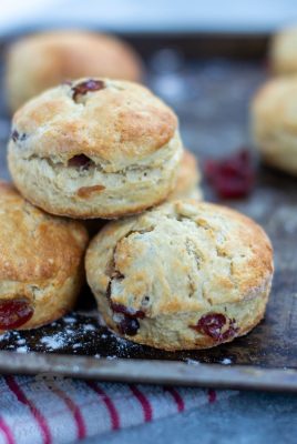 Cherry Scones Three cherry scones stacked on top of each other, on a baking tray and red chequered tea towel.