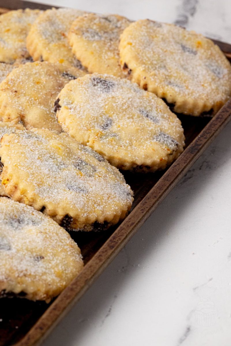 Chocolate Orange Shortbread Tray of freshly baked chocolate orange shortbread biscuits, each topped with a generous dusting of sugar.