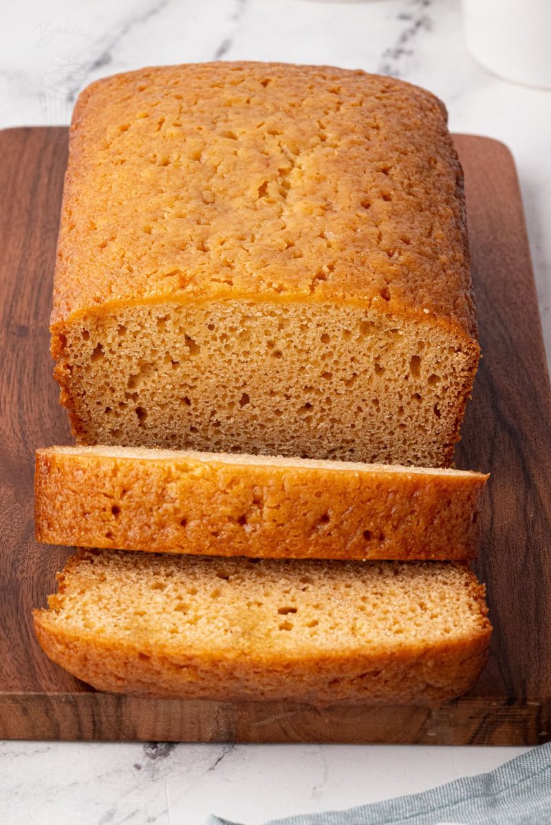 Golden Syrup Cake Golden syrup loaf cake sliced on a board with syrup glistening inside.