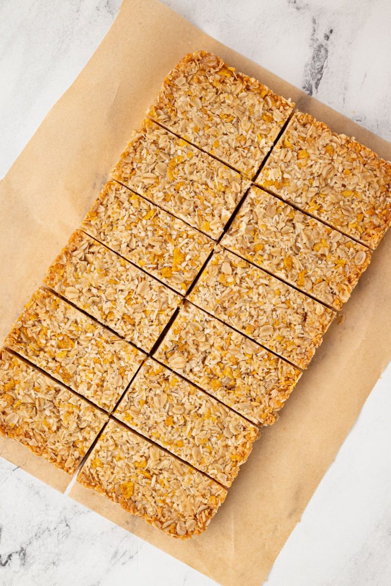 Honey Slice Overhead view of a full tray of honey slice cut into even bars on brown parchment paper.